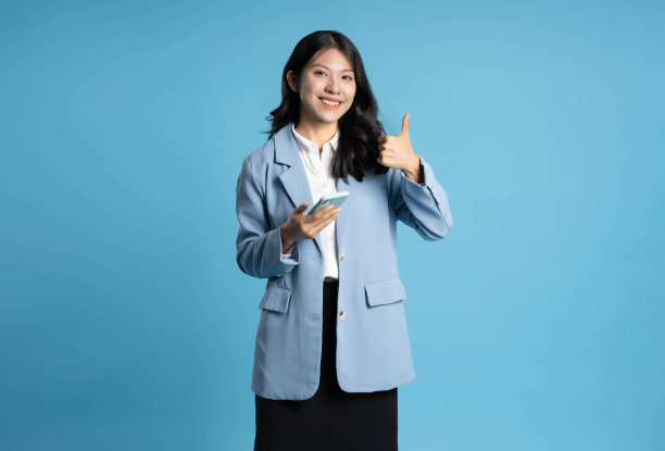 蓝色背景的年轻女商人使用手机的图片图片下载