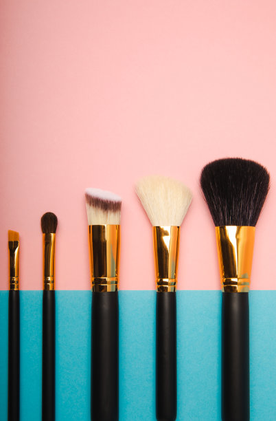 化妆用的化妆品。化妆刷在粉红色的背景上。创意时尚理念。化妆刷的集合，俯视图，横幅。平的。图片下载