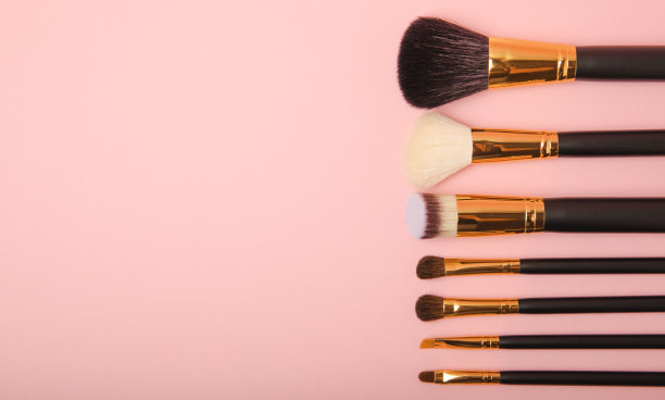 化妆用的化妆品。化妆刷在粉红色的背景上。创意时尚理念。化妆刷的集合，俯视图，横幅。平的。图片下载