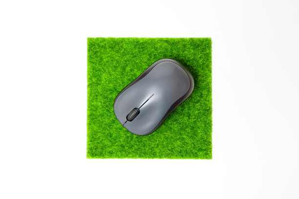 无线电脑鼠标放在绿草鼠标垫上图片下载