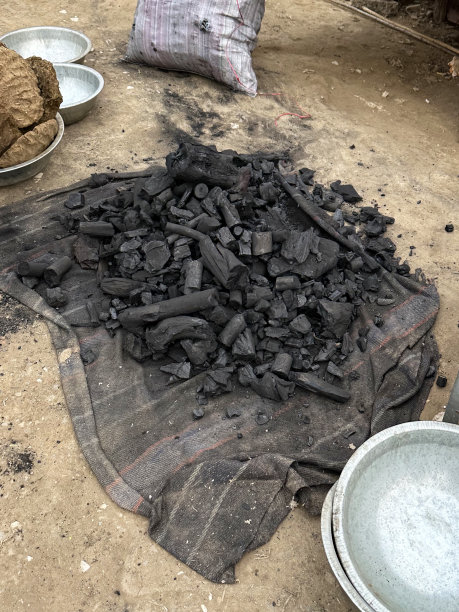 特写图片:一堆烧焦的原木和树枝放在毯子上，烧焦的木头，街边市场明火和烧烤的燃料，高架视图图片下载