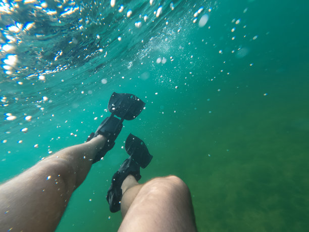 水下照片，一个男人的腿在水下鳍。图片下载