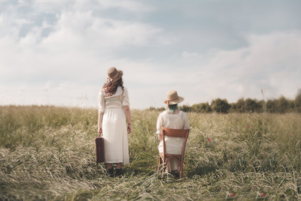 一个外出旅行的女人和另一个坐着的女人之间的超现实对比，抽象的概念图片下载