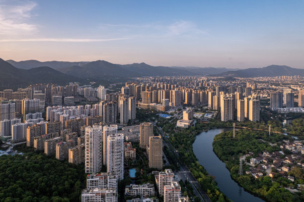 傍晚河边的城市建筑和森林鸟瞰图图片下载