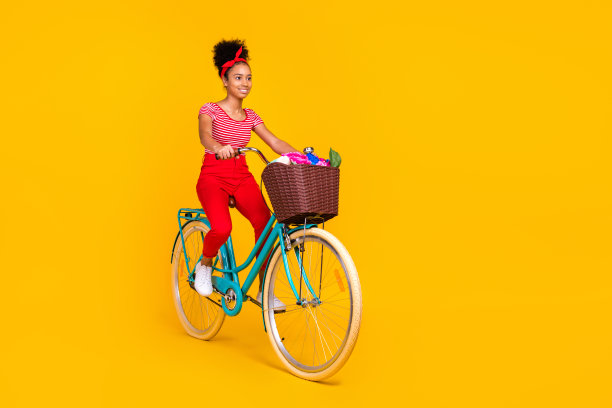 小开朗可爱的女孩骑自行车的全尺寸的个人资料照片鲜花篮子看起来空的空间孤立在黄色的背景图片下载