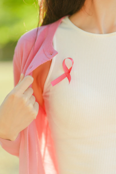 剪短的照片，一个微笑自信的中年妇女，她的衣服上系着粉红色的丝带图片下载