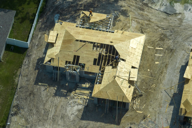 佛罗里达州农村地区，专业建筑商在未完工的郊区木结构住宅屋顶施工。美国的住房发展概念图片下载