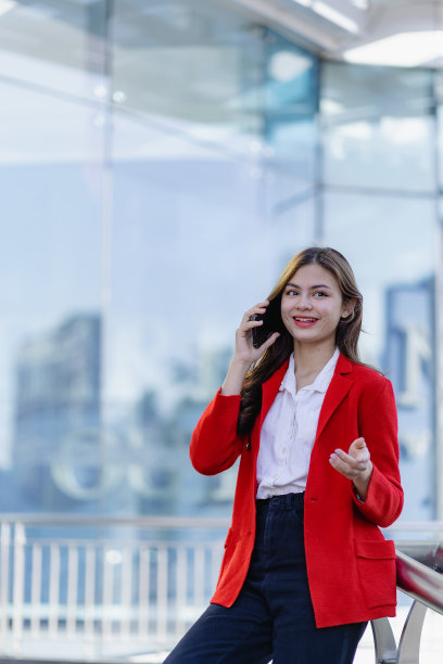 可爱的专业商务女性在户外使用智能手机与合作伙伴讨论业务垂直图片图片下载