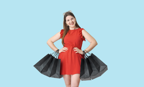 一个购物狂，手里拿着很多包，面带微笑图片下载
