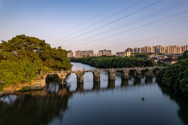 傍晚河边的城市建筑和森林鸟瞰图图片下载