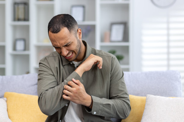 在家中沙发上扶着手腕的年轻非裔男人特写照片图片下载