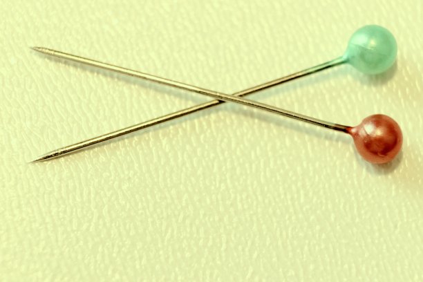 黄色背景上有绿色和红色头的别针图片下载