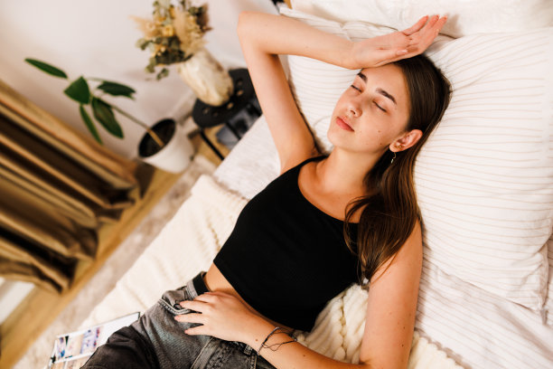 月经，月经周期每月的一天，小时少女，她手胃痛，患有经前综合症，腹部或腹部疼痛在家里的床上。健康问题身体发炎图片下载