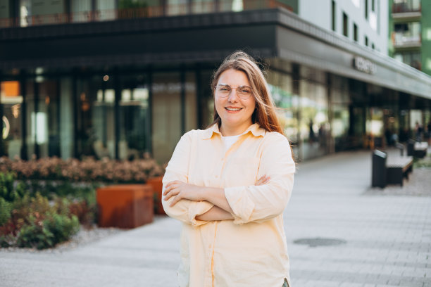 照片迷人迷人的女人可爱的短发双臂交叉自信的人工作人员友好的微笑好心情穿着办公室衬衫站在城市背景图片下载