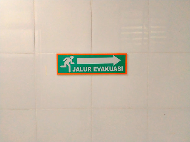 “疏散路线”的指示标志贴在瓷砖墙上图片下载