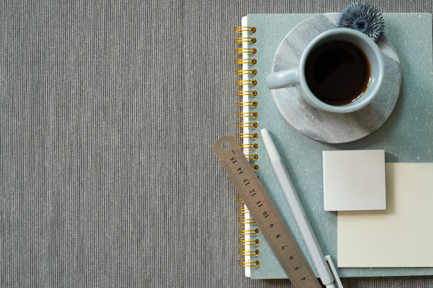 办公文具用品。笔记，笔，尺子，便签本，一杯咖啡在灰色的织物背景。俯视图，复制空间。工作空间图片下载