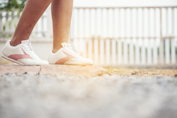 年轻女子跪下来系鞋带。在运动锻炼中准备跑鞋慢跑者。近距离的手绑跑步者的鞋带在健身房健康的人的生活方式。图片下载