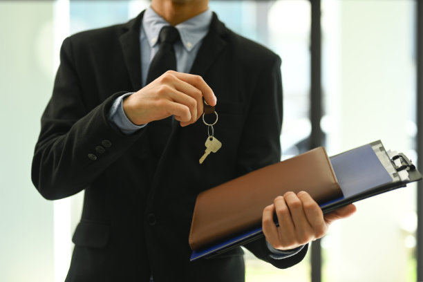专业男性房地产经纪人或经纪人手持钥匙和合同文件的裁剪照片。房地产服务理念图片下载