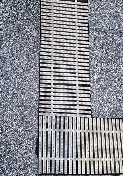 一张木制地板的照片，上面有一个金属格栅，地上的井盖上有一个木条。图片下载