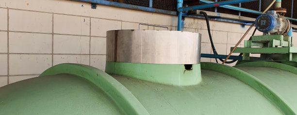 一个大型的绿色管道与金属管道支架的照片，桶式水处理机组与绿色管道和蓝色管道。图片下载