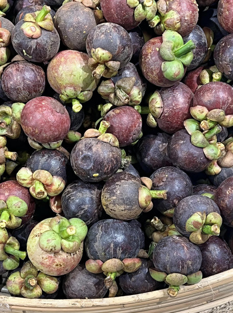 一篮子绿叶芒果、蛋奶苹果和李子在市场上的照片。图片下载