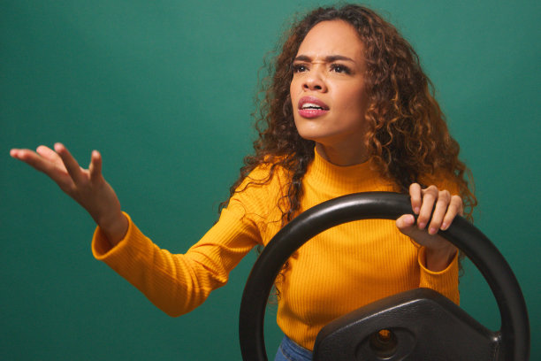 年轻女子经历路怒症，开车时生气，绿色工作室背景图片下载