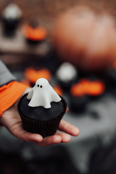 在秋天的户外，万圣节纸杯蛋糕和节日装饰在树上的枫叶图片下载