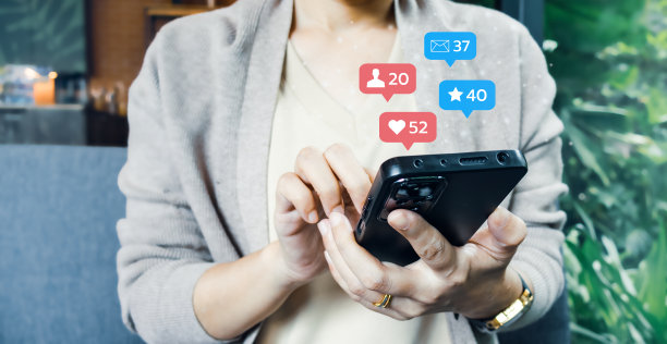 年轻女子手持手机使用社交媒体，在线与人联系。图片下载