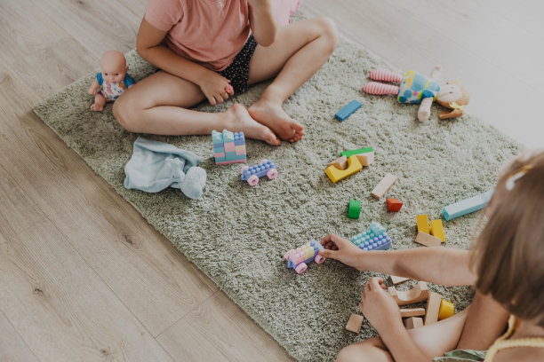 孩子们在家里或幼儿园的地板上玩玩具积木图片下载