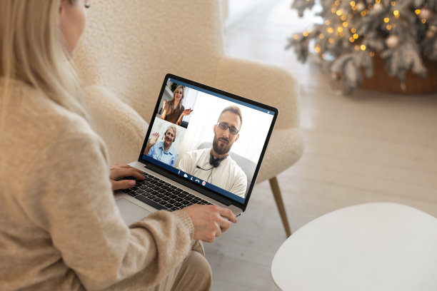 兴奋微笑的女人用笔记本电脑视频聊天。年轻的女性在家里有快乐的圣诞心情。图片下载