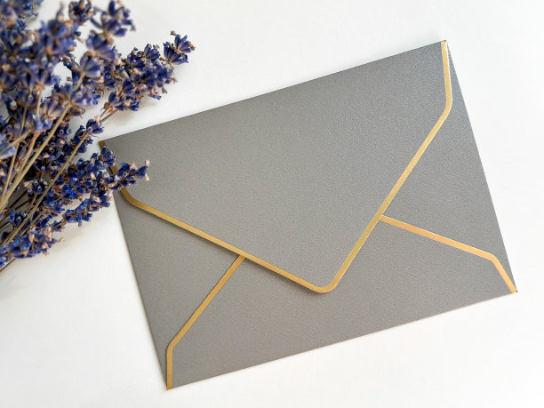 精致的婚礼文具套装。婚礼请柬模板，银色信封，干薰衣草花在一个白色的背景。平铺，俯视图，复制空间。图片下载