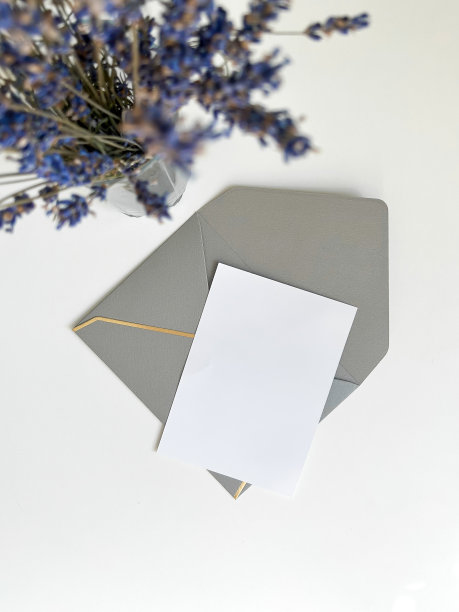 精致的婚礼文具套装。婚礼请柬模板，银色信封，干薰衣草花在一个白色的背景。平铺，俯视图，复制空间。图片下载