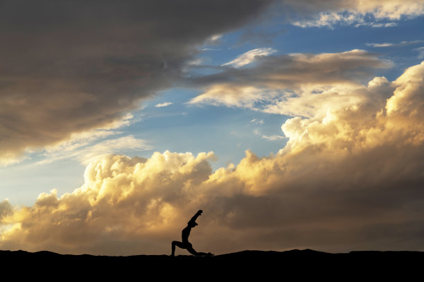 女人的剪影在夜晚跳舞，在明亮的夕阳背景下。图片下载