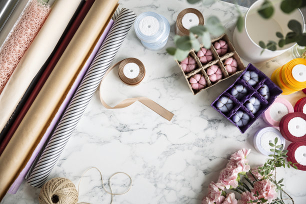 花店工作空间平铺:粉红色康乃馨花、麻绳、锚、修剪器和桉树叶子放在大理石桌子背景上，中间有空间，俯视图图片下载