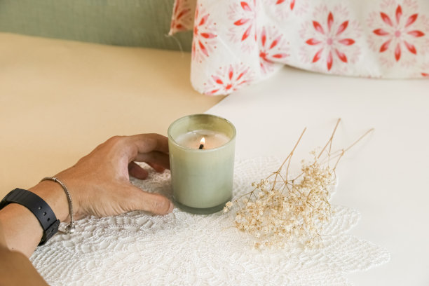 男孩在家里的书桌上点了一支蜡烛。处理完迷你花后放松一下。放松和禅宗气氛股票照片图片下载