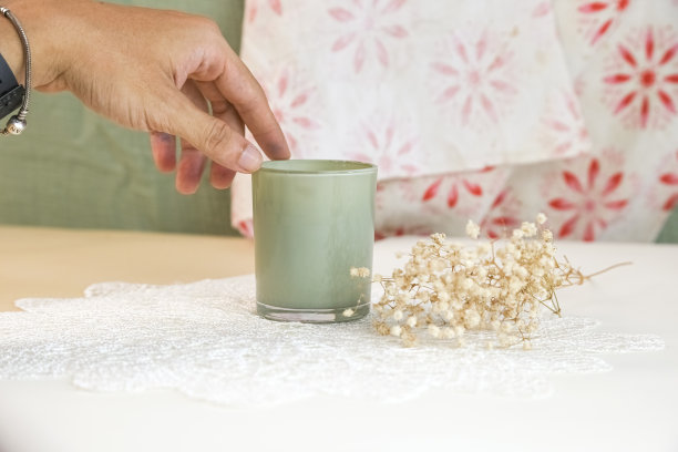 男孩在家里的书桌上点了一支蜡烛。处理完迷你花后放松一下。放松和禅宗气氛股票照片图片下载