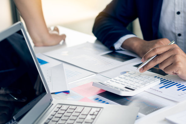 会计分析发票投资图表，并按下计算器按钮在文件会计文员，银行顾问和审核员在办公室的特写照片图片下载