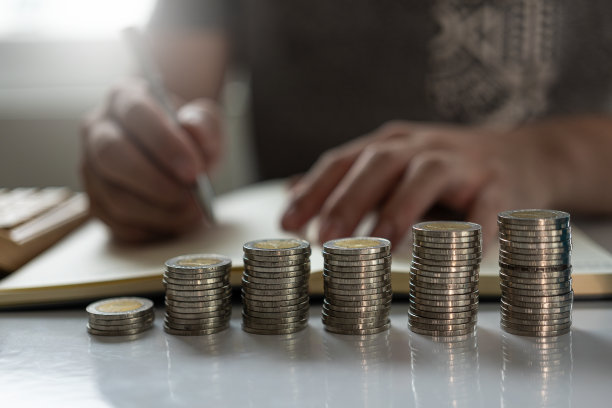 年轻人和一堆硬币计划增加储蓄策略和一堆硬币为未来规划基金。特写照片图片下载