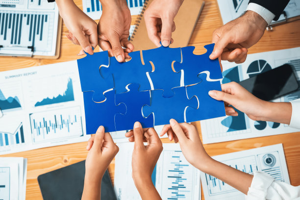 多民族商人将拼图拼凑在一起。服装图片下载