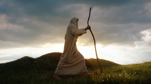 基督的剪影在太阳的背后爬上一座小山图片下载