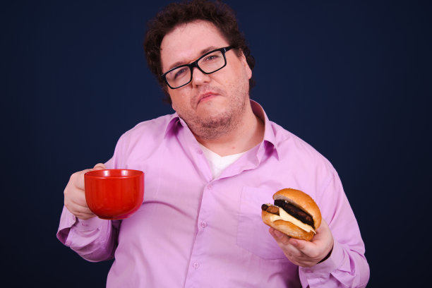 有趣的饥饿胖子吃汉堡。图片下载