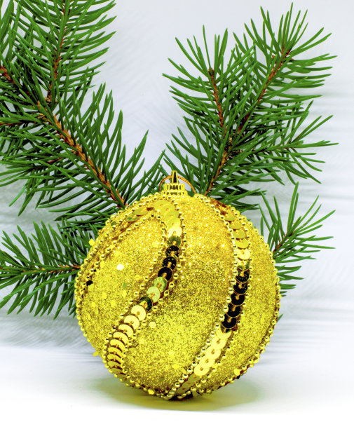 圣诞树装饰的照片，一个美丽的金色，闪亮的球，一个圣诞树的树枝。图片下载