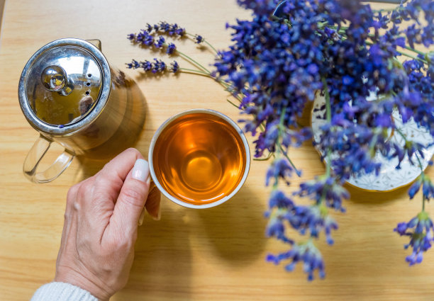 头顶上的一张照片，手里拿着一杯充满活力的茶，还有新鲜的薰衣草花图片下载