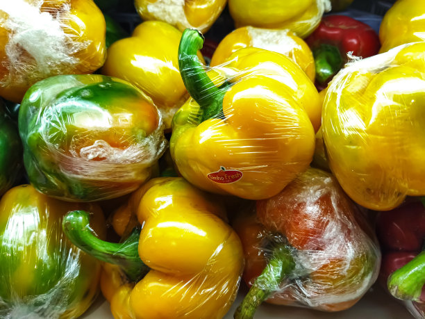 一堆塑料包裹的橙色和红色甜椒图片下载