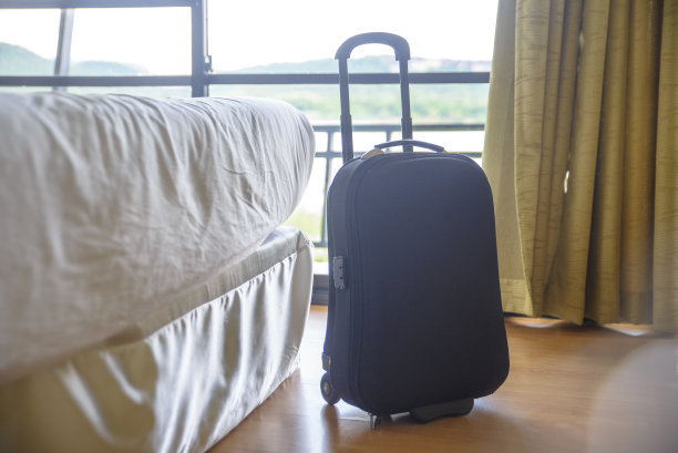 旅行时酒店卧室床上的行李或手提箱。行李旅行和居家度假的概念。图片下载