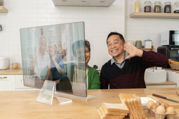 祖父母在电脑上通过视频聊天与孙子孙女在家里的厨房，退休夫妇的节日活动。图片下载