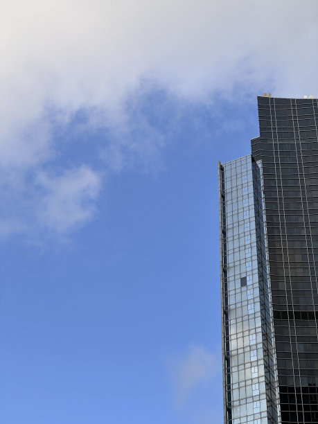 现代摩天大楼的正面视图，蓝天、云彩和复制空间。建筑背景概念图片下载