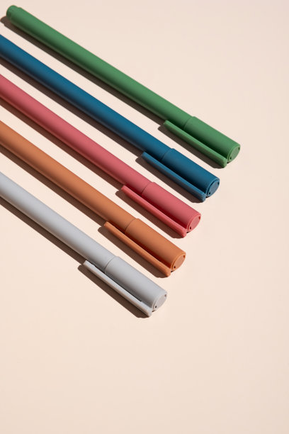 一些彩色钢笔排列在米色上。图片下载