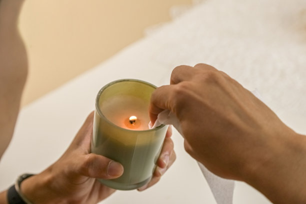 男孩在家里的书桌上点了一支蜡烛。处理完迷你花后放松一下。放松和禅宗气氛股票照片图片下载