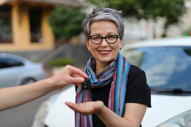 一位50多岁的成熟的白人女商人开着租来的车，自信地微笑着，代表着快乐、幸福和安全。图片下载